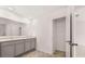 Bathroom with double vanity, gray cabinets, tile floor, and walk in closet with shelving, door ajar at 1309 Aura Ln, Lawrenceville, GA 30045