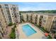 Aerial view of a community pool with lounge chairs and umbrellas surrounded by condo buildings at 711 Cosmopolitan Ne Dr # 625, Atlanta, GA 30324