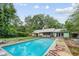 Backyard with a large in-ground pool surrounded by a spacious green yard and mature trees, ideal for outdoor living at 962 Brighton Dr, Lawrenceville, GA 30043