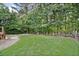 Beautifully landscaped backyard featuring a fire pit area, wood pile, and mature trees for privacy at 112 Birchwood Pass, Canton, GA 30114