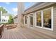 A wooden deck with a dining table set and views into the interior of the home through a large window at 112 Birchwood Pass, Canton, GA 30114