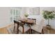 A dining room featuring hardwood floors, a modern rug, plantation shutters, and neutral colored walls at 112 Birchwood Pass, Canton, GA 30114