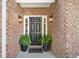 Charming brick entryway with black door, sidelights, and lantern sconces at 112 Birchwood Pass, Canton, GA 30114