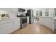 Modern kitchen featuring white cabinets, stainless steel appliances, and a breakfast bar, perfect for casual dining at 112 Birchwood Pass, Canton, GA 30114