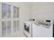 Bright laundry room featuring a washer, dryer, and folding doors at 112 Birchwood Pass, Canton, GA 30114