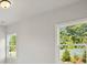 Bedroom with large windows offering natural light and a view of the surrounding greenery at 6520 Pond View Dr, Cumming, GA 30028