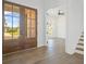 Inviting foyer with wood floors, glass paneled entry doors, and white trim staircase at 6520 Pond View Dr, Cumming, GA 30028