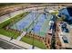Aerial view of pickleball courts in a new home community with manicured landscaping and lighting at 6520 Pond View Dr, Cumming, GA 30028