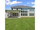 Well-manicured lawn and large windows accent the rear of this two-story home at 6520 Pond View Dr, Cumming, GA 30028