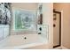 Bright bathroom featuring a soaking tub, a separate shower, and modern fixtures for a relaxing experience at 79 Little Creek Manor Dr, Dallas, GA 30157