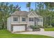 Two-story home with stone accents, blue shutters, a well-kept lawn, attached garage, and set among mature trees at 79 Little Creek Manor Dr, Dallas, GA 30157