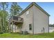 Back exterior elevation of home with upper wood deck and a grassy backyard at 79 Little Creek Manor Dr, Dallas, GA 30157