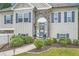 A beautifully landscaped home entrance features blue shutters, stone accents, and a charming flower garden at 79 Little Creek Manor Dr, Dallas, GA 30157