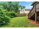 Well-maintained backyard with green grass, wooden fence, and stairs leading to a deck at 944 Deckner Sw Ave, Atlanta, GA 30310