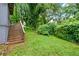 Lush backyard with green grass, wooden fence, and stairs leading to a deck at 944 Deckner Sw Ave, Atlanta, GA 30310