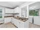 Well-lit kitchen featuring white cabinetry, tile floors, and stainless steel appliances at 944 Deckner Sw Ave, Atlanta, GA 30310
