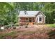 Cozy home with a metal roof, porch, and inviting landscaping, surrounded by mature trees at 141 Mills Creek Path, Hiram, GA 30141