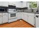 Charming kitchen features white cabinetry, gray countertops, and wood-look flooring at 141 Mills Creek Path, Hiram, GA 30141