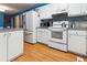 Open kitchen with white cabinets, granite counters, and wood-look floors at 141 Mills Creek Path, Hiram, GA 30141