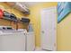 Bright laundry room features modern washer and dryer, with ample shelving for organized storage at 141 Mills Creek Path, Hiram, GA 30141