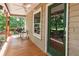 Relaxing side porch with wooden floor, outdoor furniture, and a view of surrounding greenery at 141 Mills Creek Path, Hiram, GA 30141