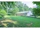 Expansive backyard showing the house with a beautiful yard, lush trees, and a partial fence at 2173 Martin Way, Jonesboro, GA 30236