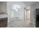 View of kitchen with eat-in area with large window, white cabinets, and granite countertops and tile floors at 2173 Martin Way, Jonesboro, GA 30236