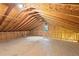 Spacious unfinished attic space with exposed wooden beams and a small window at 3345 Bomar Rd, Douglasville, GA 30135