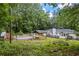 A wide view of the fenced-in backyard showing pool, picnic table, lush trees, and home at 3345 Bomar Rd, Douglasville, GA 30135