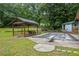 View of covered picnic table, and pool covered with safety netting, surrounded by lush greenery at 3345 Bomar Rd, Douglasville, GA 30135