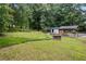 Wide shot of spacious backyard with picnic table, covered pool, and lush trees at 3345 Bomar Rd, Douglasville, GA 30135