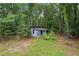 Rustic outbuilding nestled in a lush, wooded setting; ideal for storage or a creative space at 3345 Bomar Rd, Douglasville, GA 30135