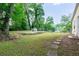 Spacious backyard featuring a lush lawn, mature trees, stepping stones, and a fenced boundary at 3349 Lavista Dr, Atlanta, GA 30354