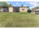 View of back of property including a screened in porch, yard, and mature trees at 1101 New Horizon St, Powder Springs, GA 30127