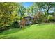Lush backyard showcasing mature trees and a view of the rear exterior with deck at 3402 Johnson Ferry Rd, Roswell, GA 30075