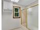 Bathroom featuring a bathtub with glass enclosure, a window and white walls at 3402 Johnson Ferry Rd, Roswell, GA 30075