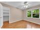 Relaxing bedroom with hardwood floors, closet, ceiling fan, and bright windows overlooking a wooded area at 3402 Johnson Ferry Rd, Roswell, GA 30075