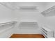 Walk-in closet with built-in shelving and hardwood floors at 3402 Johnson Ferry Rd, Roswell, GA 30075