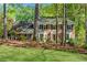 Beautiful brick home with manicured lawn, mature trees, and bay windows at 3402 Johnson Ferry Rd, Roswell, GA 30075