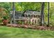 Beautiful brick home with manicured lawn, mature trees, and bay windows at 3402 Johnson Ferry Rd, Roswell, GA 30075
