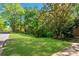 Beautifully landscaped front lawn featuring mature trees and lush green grass at 3402 Johnson Ferry Rd, Roswell, GA 30075
