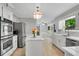 Modern kitchen with stainless steel appliances, island with seating, and ample cabinet space at 3402 Johnson Ferry Rd, Roswell, GA 30075