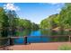 Stunning lake view from wooden deck surrounded by lush green trees and blue sky at 3402 Johnson Ferry Rd, Roswell, GA 30075