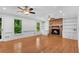 Cozy living room featuring a brick fireplace, hardwood floors, and built-in shelving at 3402 Johnson Ferry Rd, Roswell, GA 30075