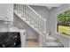 Staircase with carpet runner leading upstairs, with a nearby laundry area and natural light from a window at 3402 Johnson Ferry Rd, Roswell, GA 30075