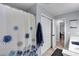 This bathroom offers a shower with a decorative shower curtain and neutral tile flooring at 4012 Ironhill Ln, Woodstock, GA 30189