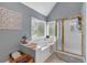 Bathroom with a soaking tub with jets and a glass enclosed shower at 4012 Ironhill Ln, Woodstock, GA 30189