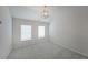 Bright bedroom featuring neutral walls, plush carpeting, a modern light fixture, and two windows at 4450 Richmond Ct, Stone Mountain, GA 30083