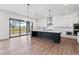 Bright kitchen features an island, stainless steel appliances, hardwood floors, and a sliding glass door leading to the deck at 4825 Gadwall Way, Cumming, GA 30028