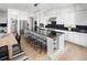 Modern kitchen featuring sleek white cabinetry, a black countertop island with seating, and stainless steel appliances at 4825 Gadwall Way, Cumming, GA 30028
